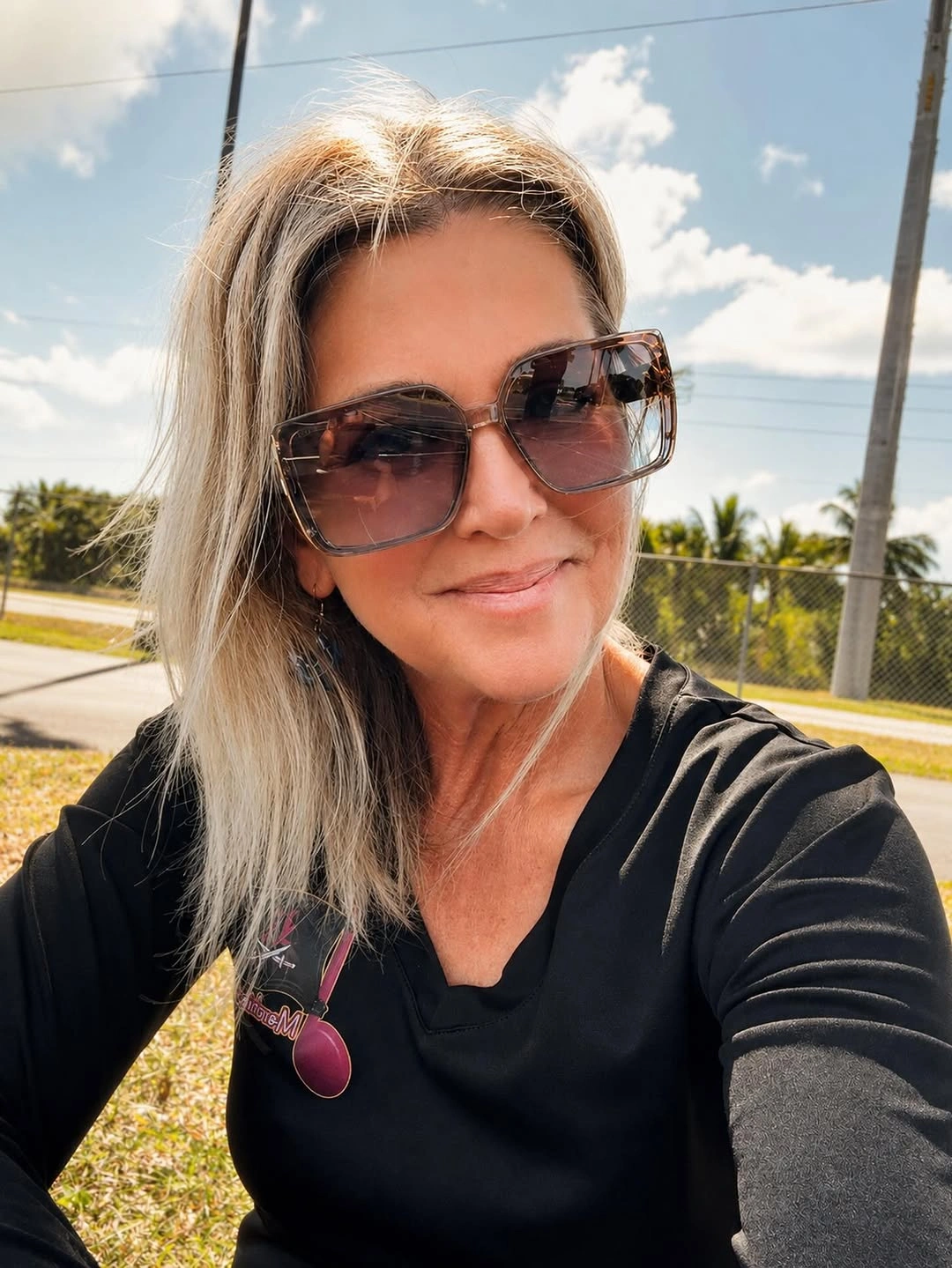 Straight blonde shoulder skimming hair with large sunglasses