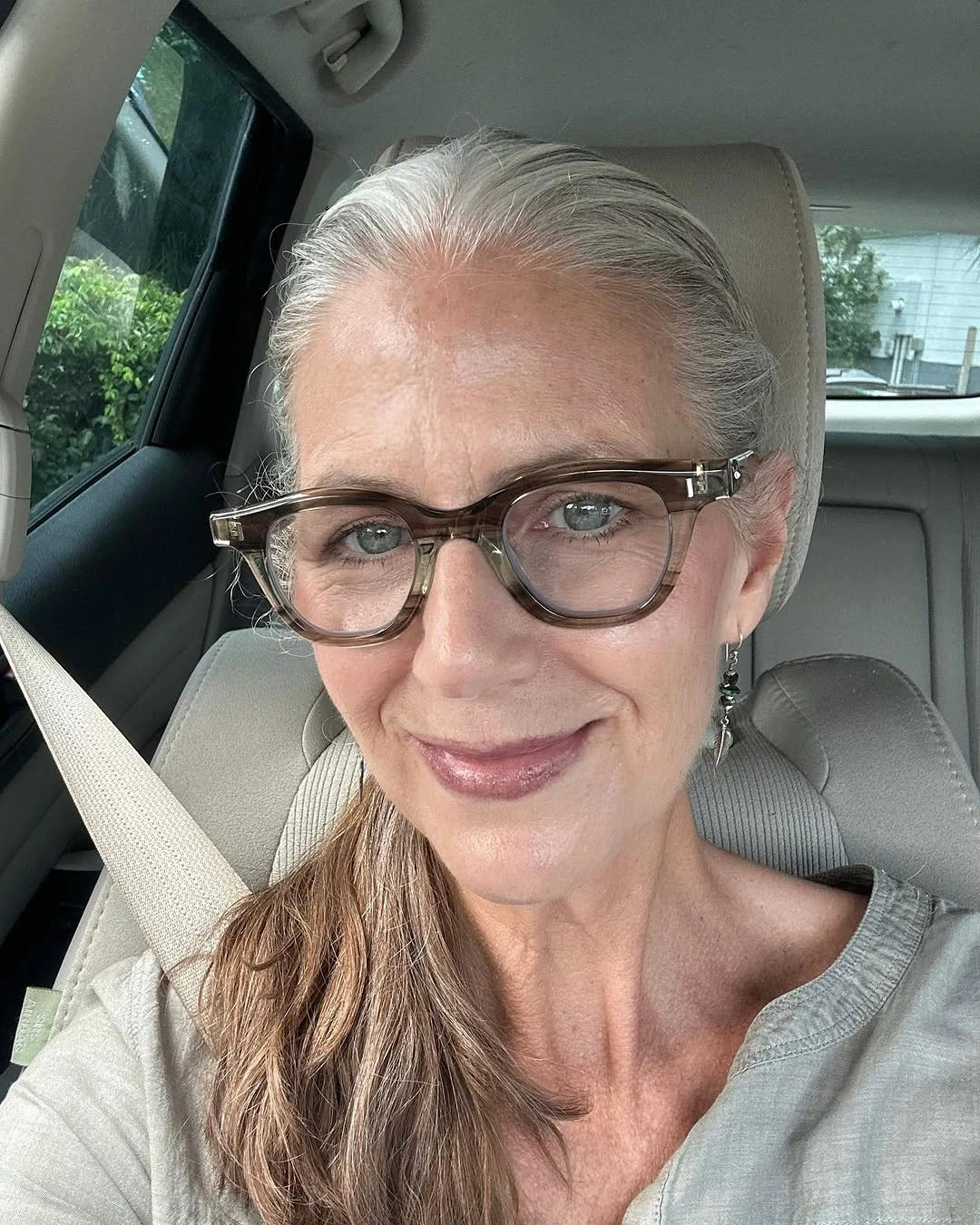 Long silver gray hair worn back with glasses