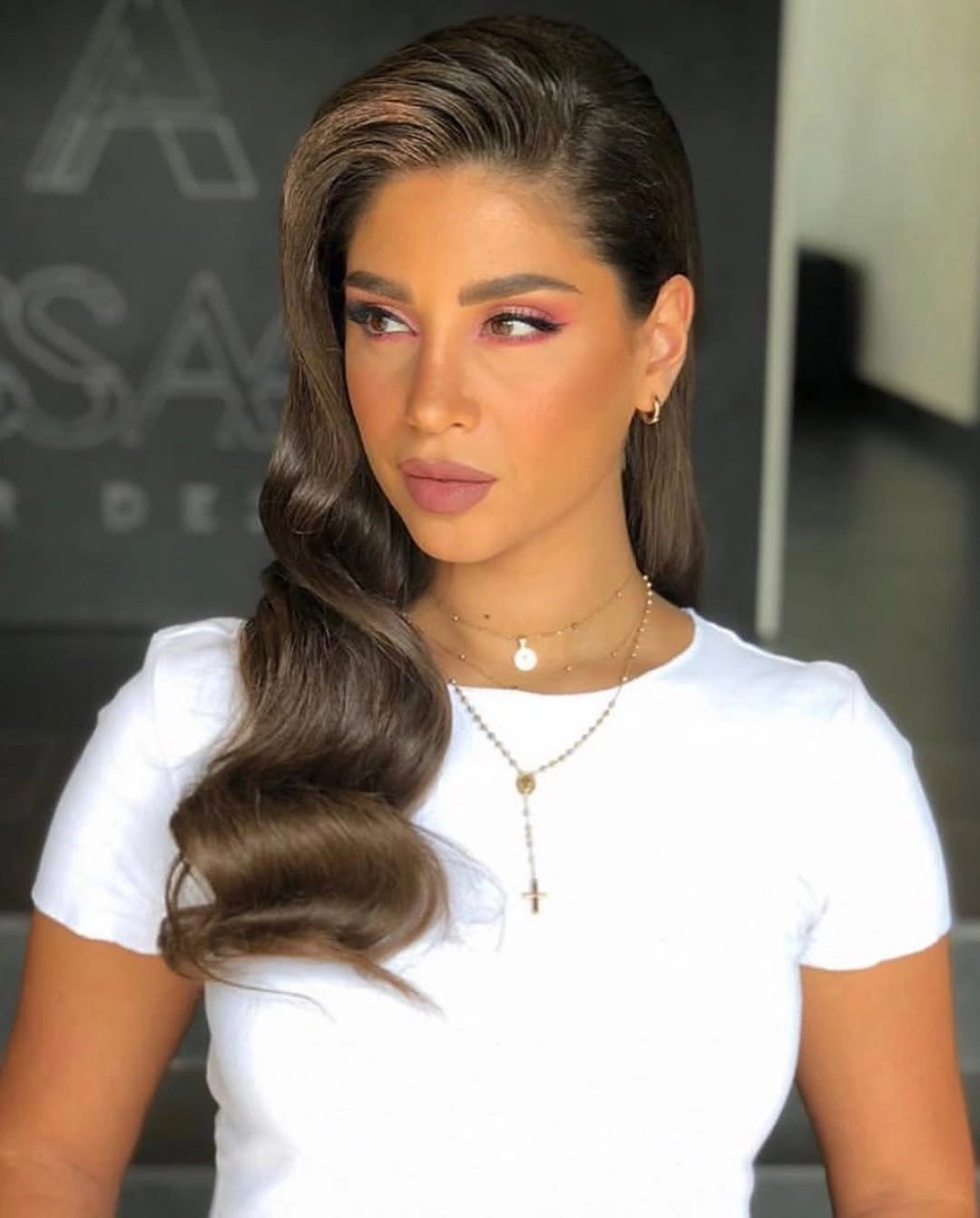 Long brunette waves swept to one side over shoulder