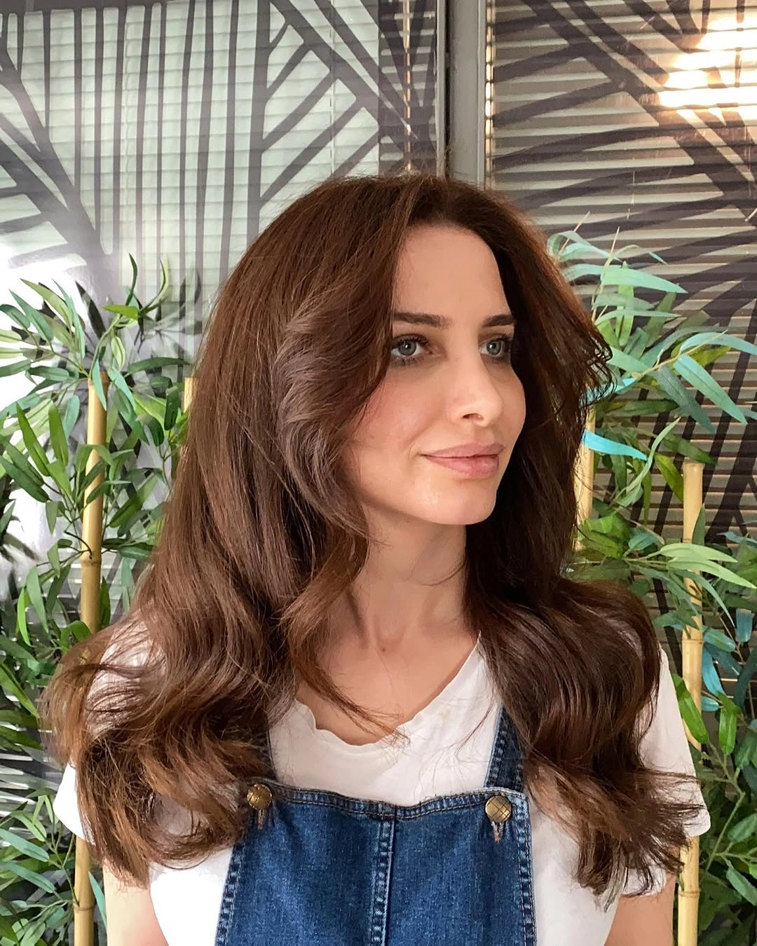Long warm brunette hair with centered waves and fullness