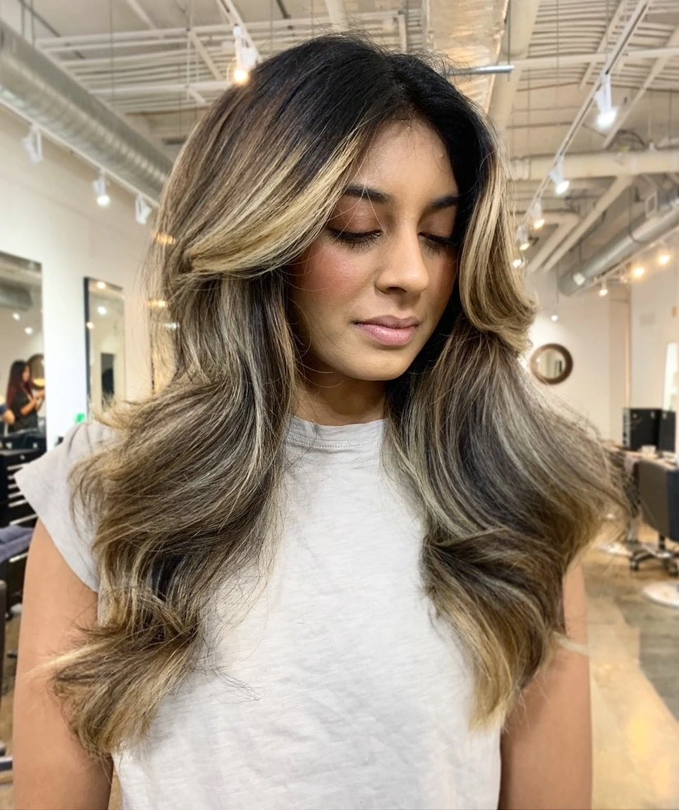 Long dark wavy hair with light face-framing sections