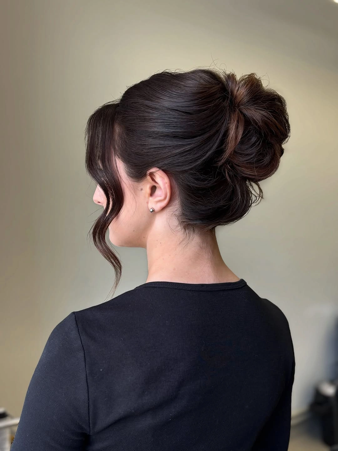 Dark gathered updo with textured bun and loose curl