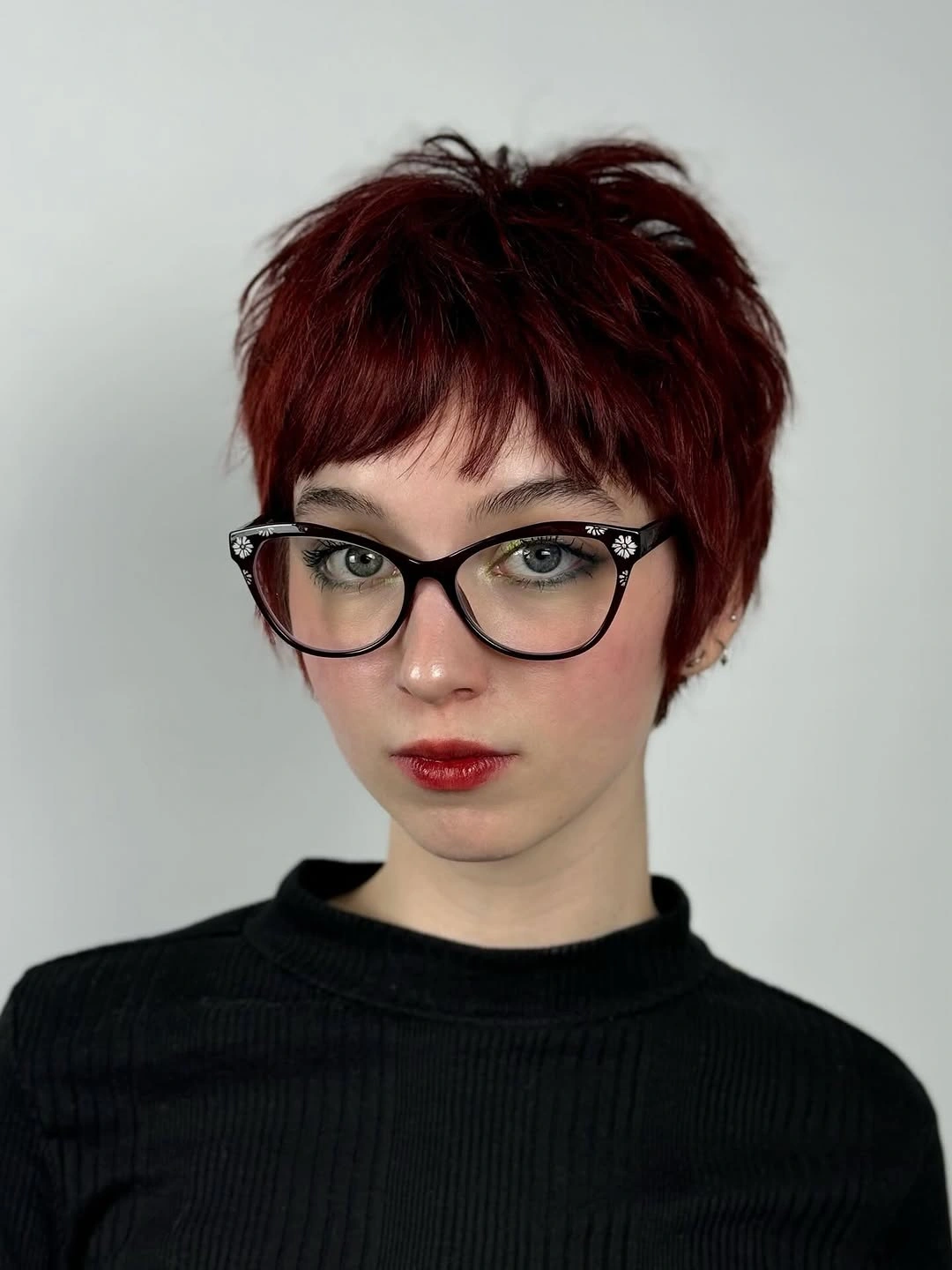 Short deep red textured hair with glasses and fringe