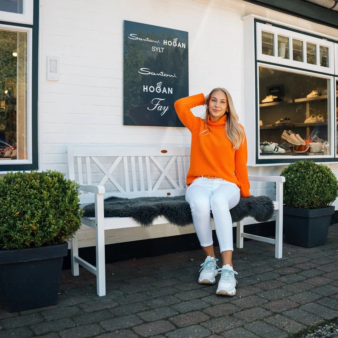Orange turtleneck with white pants and chunky sneakers