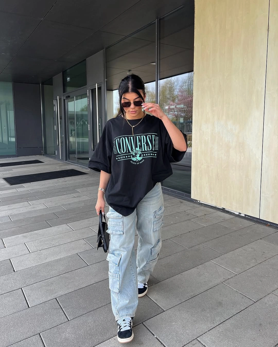 Oversized black graphic tee with light cargo jeans and sneakers