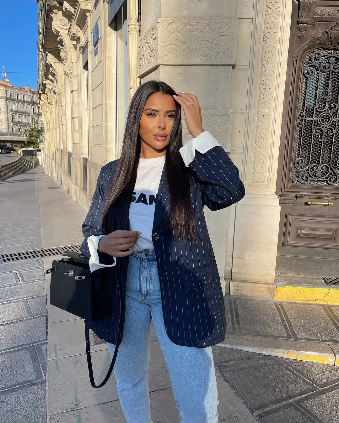 Navy pinstripe blazer with graphic tee and light jeans