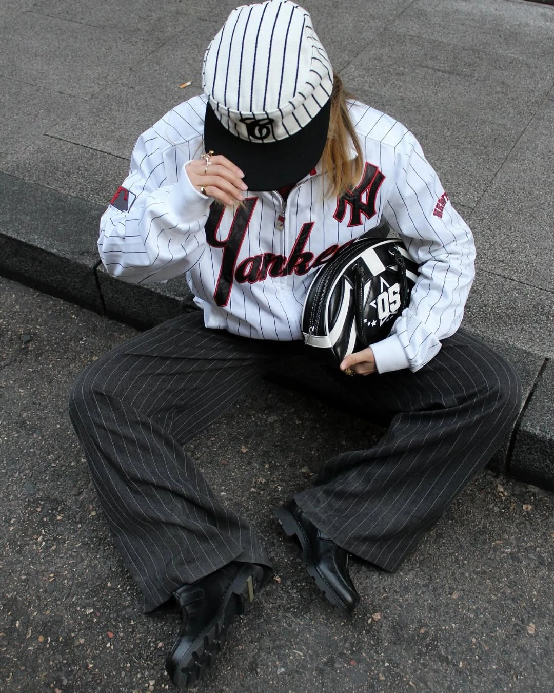 Pinstriped sport-inspired top with dark wide trousers and chunky shoes