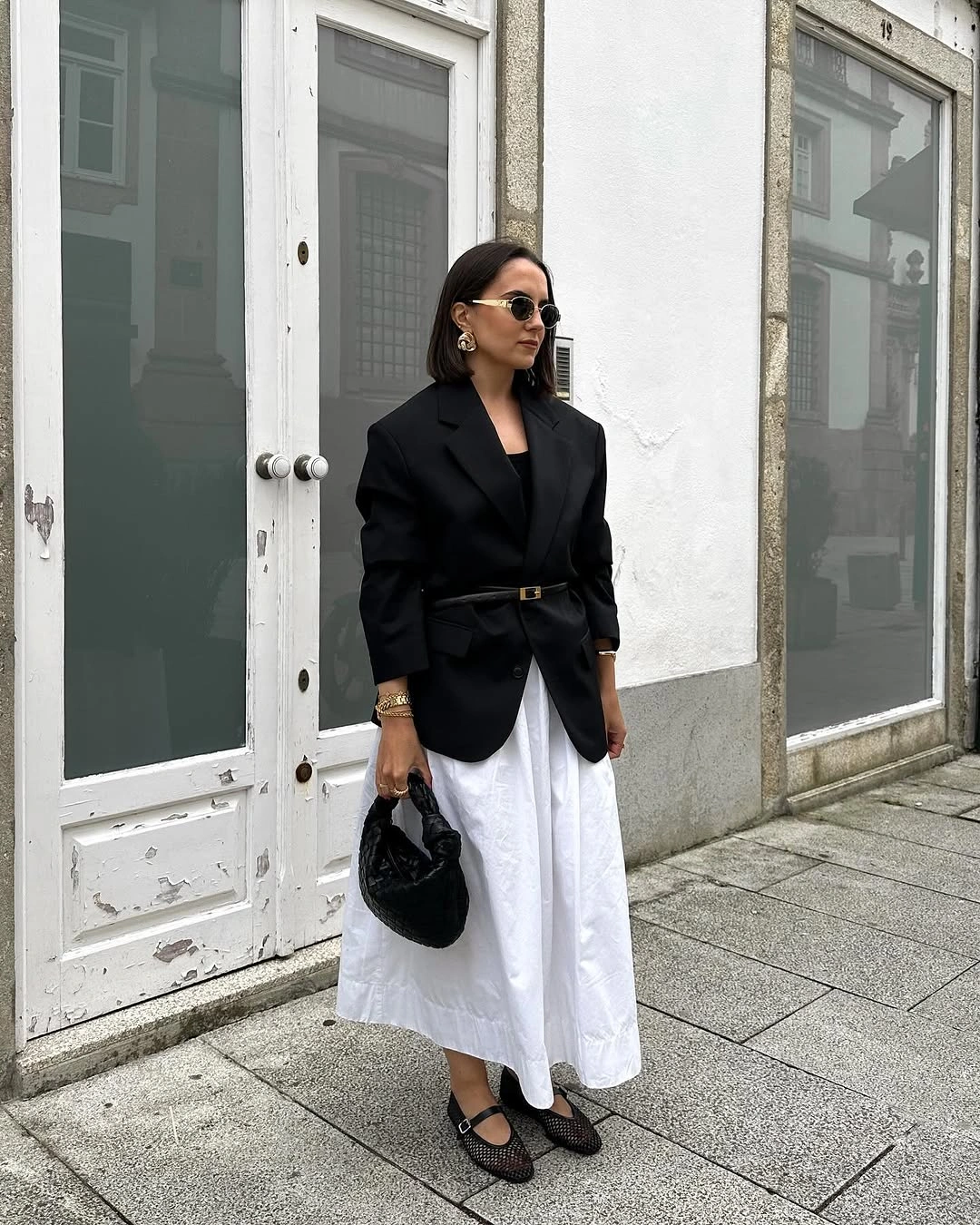 Belted black blazer with full white midi skirt and mesh flats