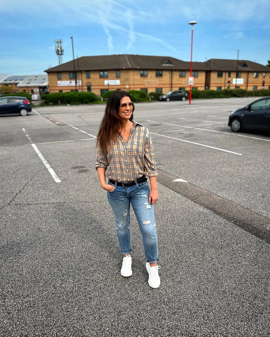 Plaid shirt with distressed jeans, white sneakers and black belt
