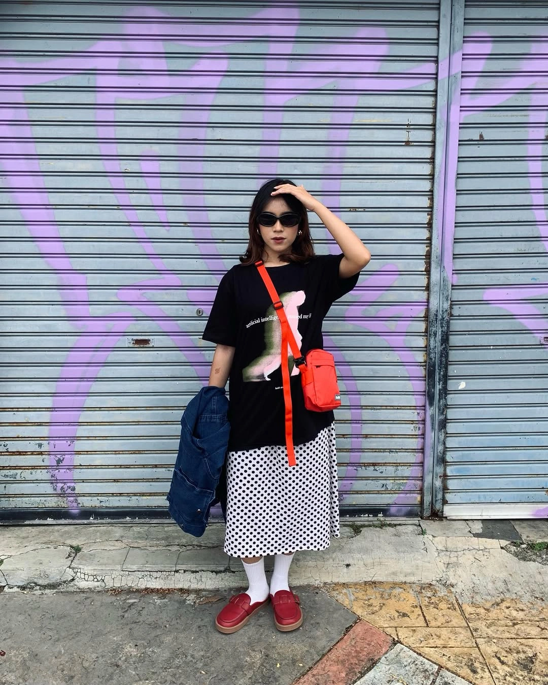 Graphic tee with polka-dot skirt, red loafers and crossbody bag