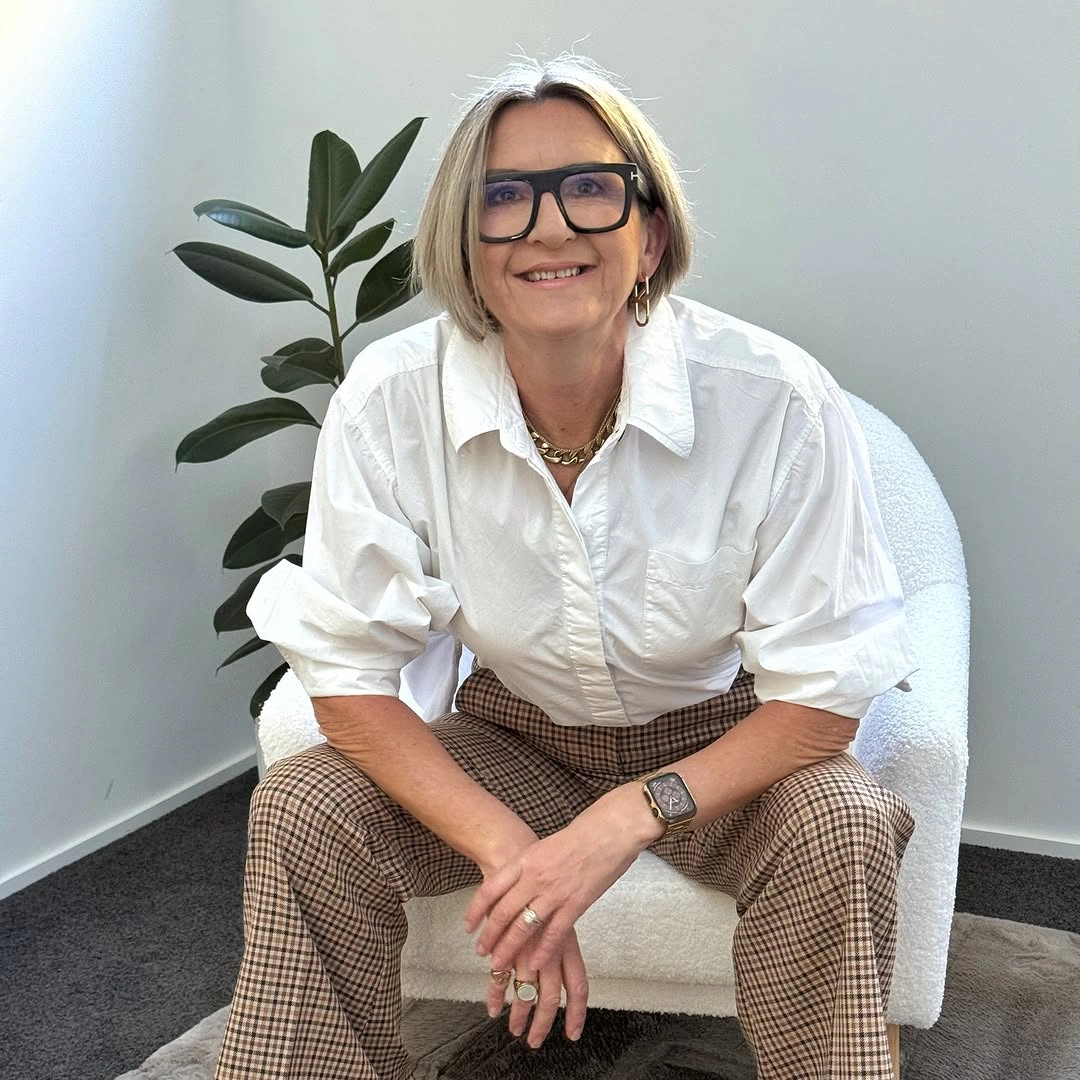 White rolled-sleeve shirt with brown checked trousers and glasses