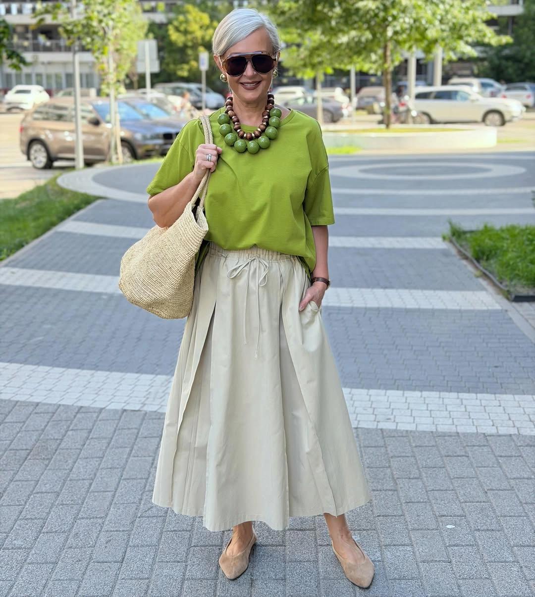Lime green top with cream skirt, beads, woven tote and flats