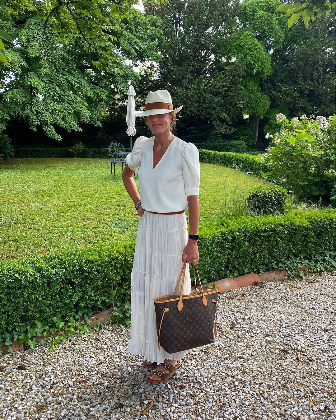 White belted outfit with straw hat, brown tote and sandals