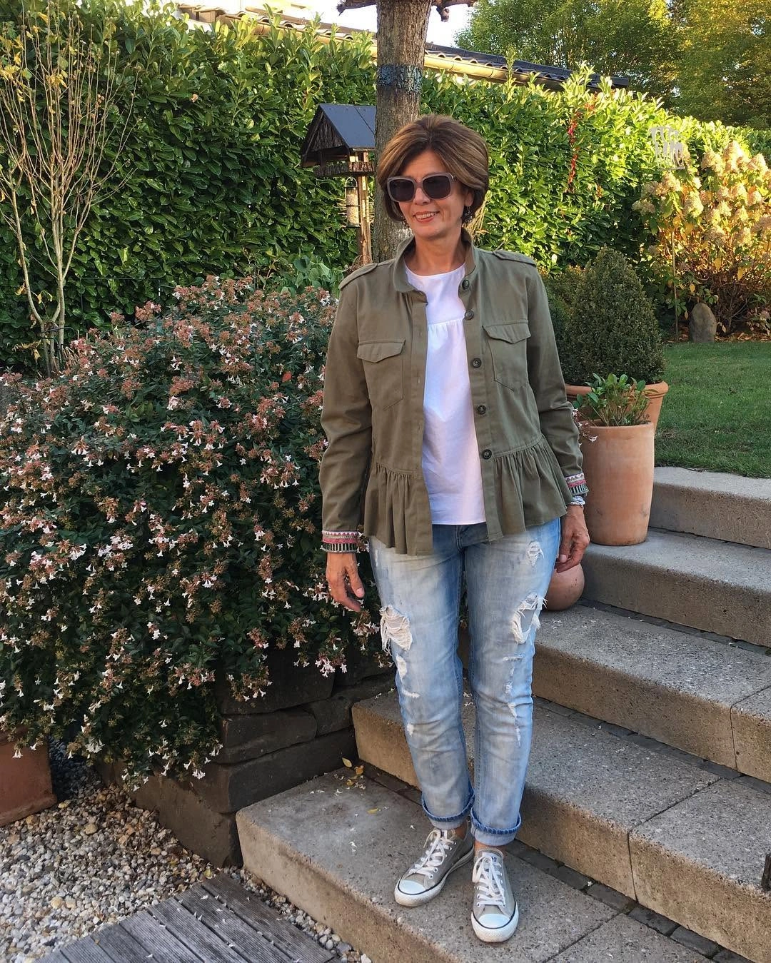 Olive utility jacket over white tee with distressed jeans and sneakers
