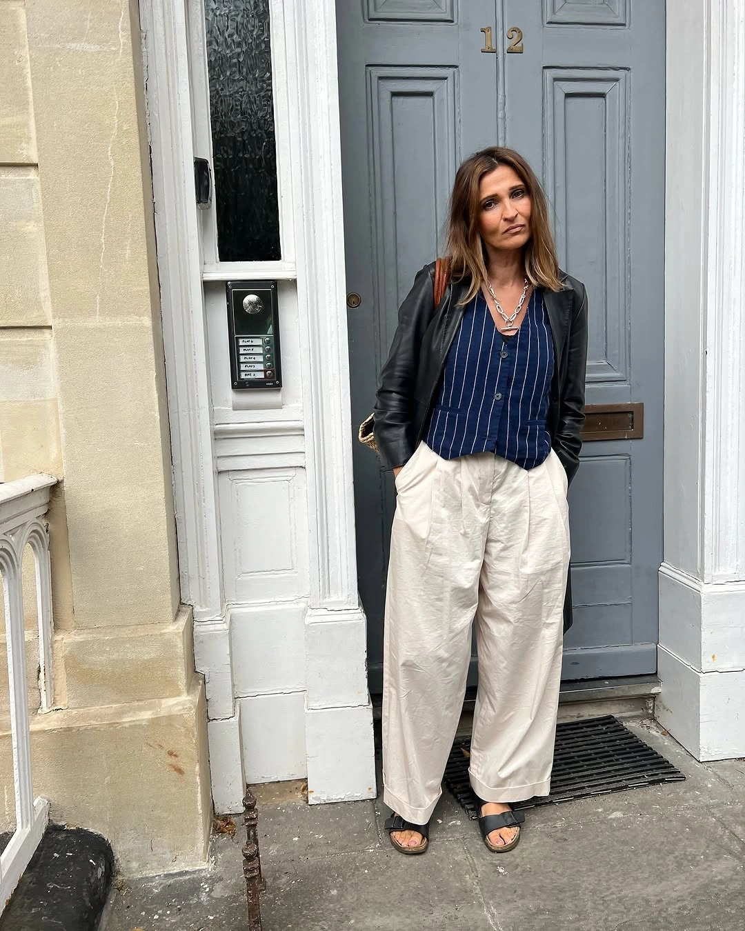 Black jacket with pinstriped top and cream pleated trousers