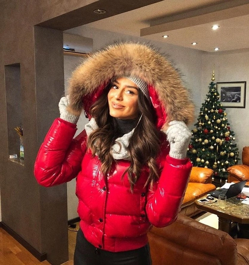 Glossy red puffer with furry-looking hood trim and white gloves