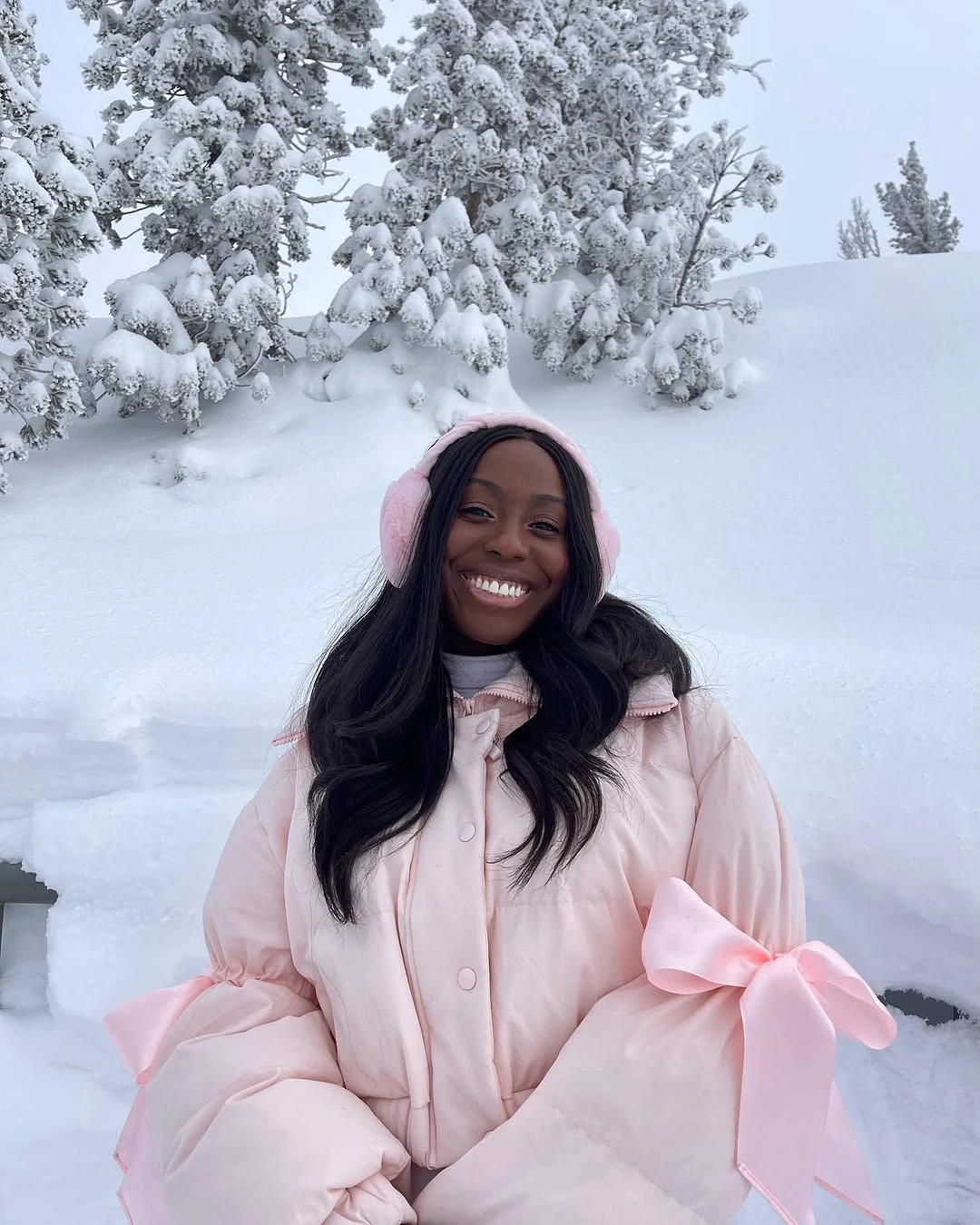 Pale pink oversized puffer with earmuffs and bow details
