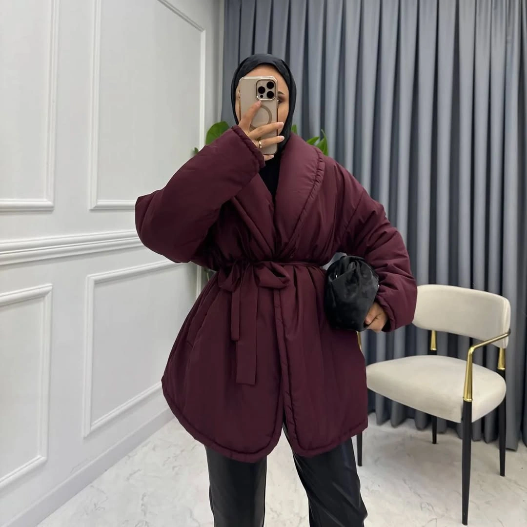 Burgundy quilted puffer-style jacket with tied waist and black pants
