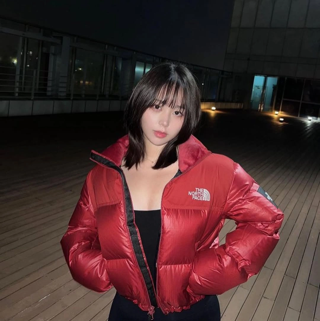 Cropped glossy red puffer worn open over black top
