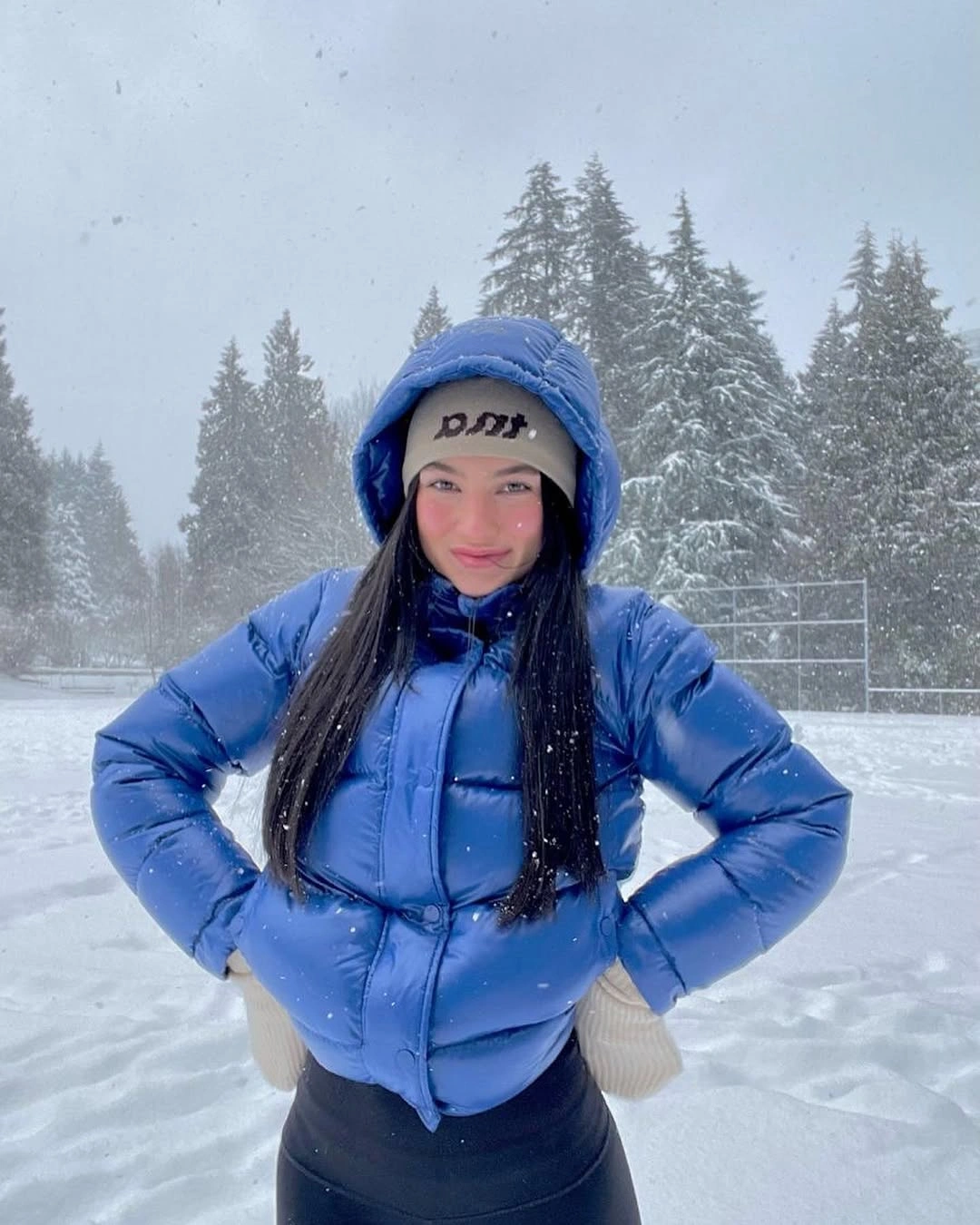 Bright blue cropped hooded puffer with headband and beige gloves