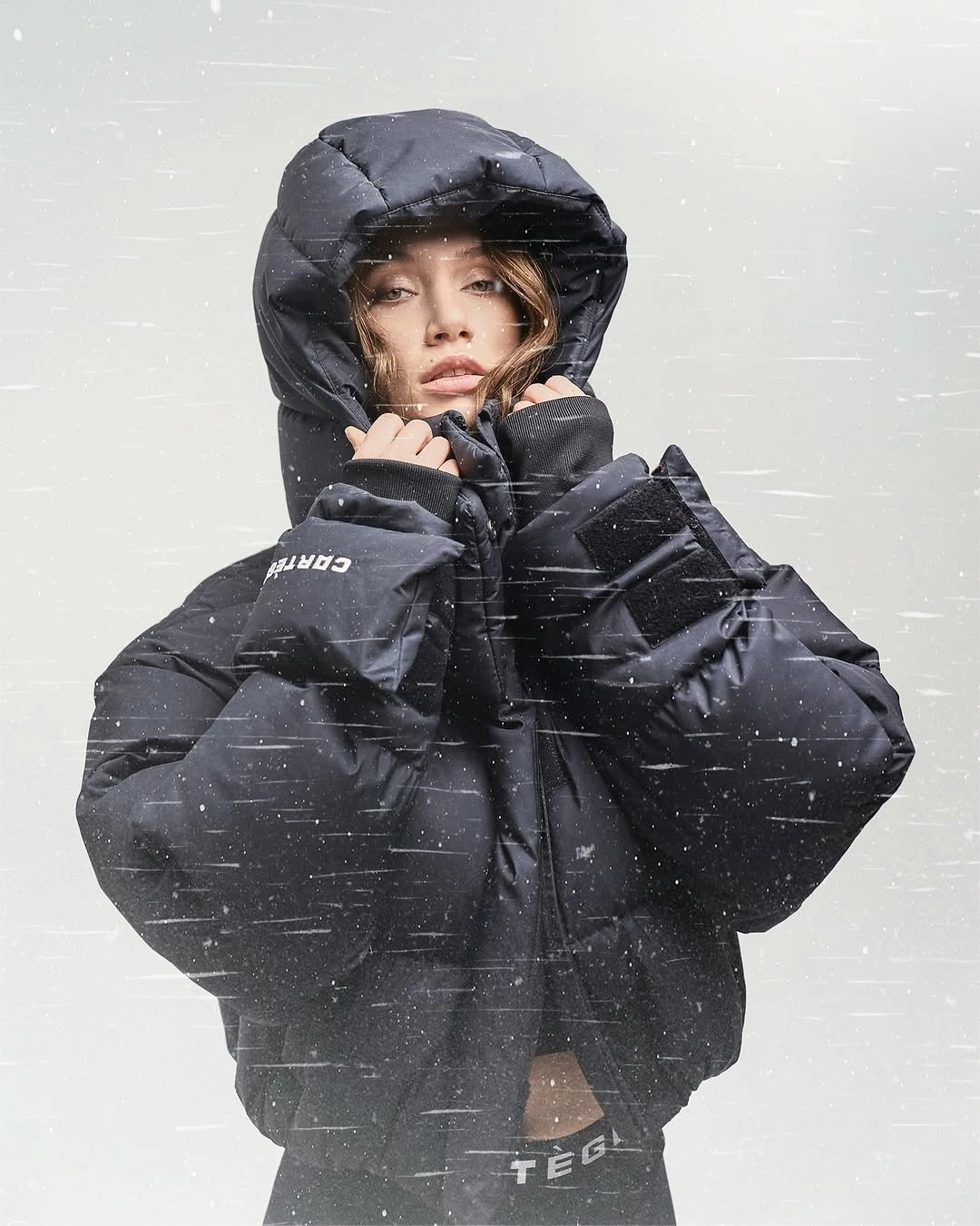 Black hooded puffer with oversized hood and dark sweatshirt