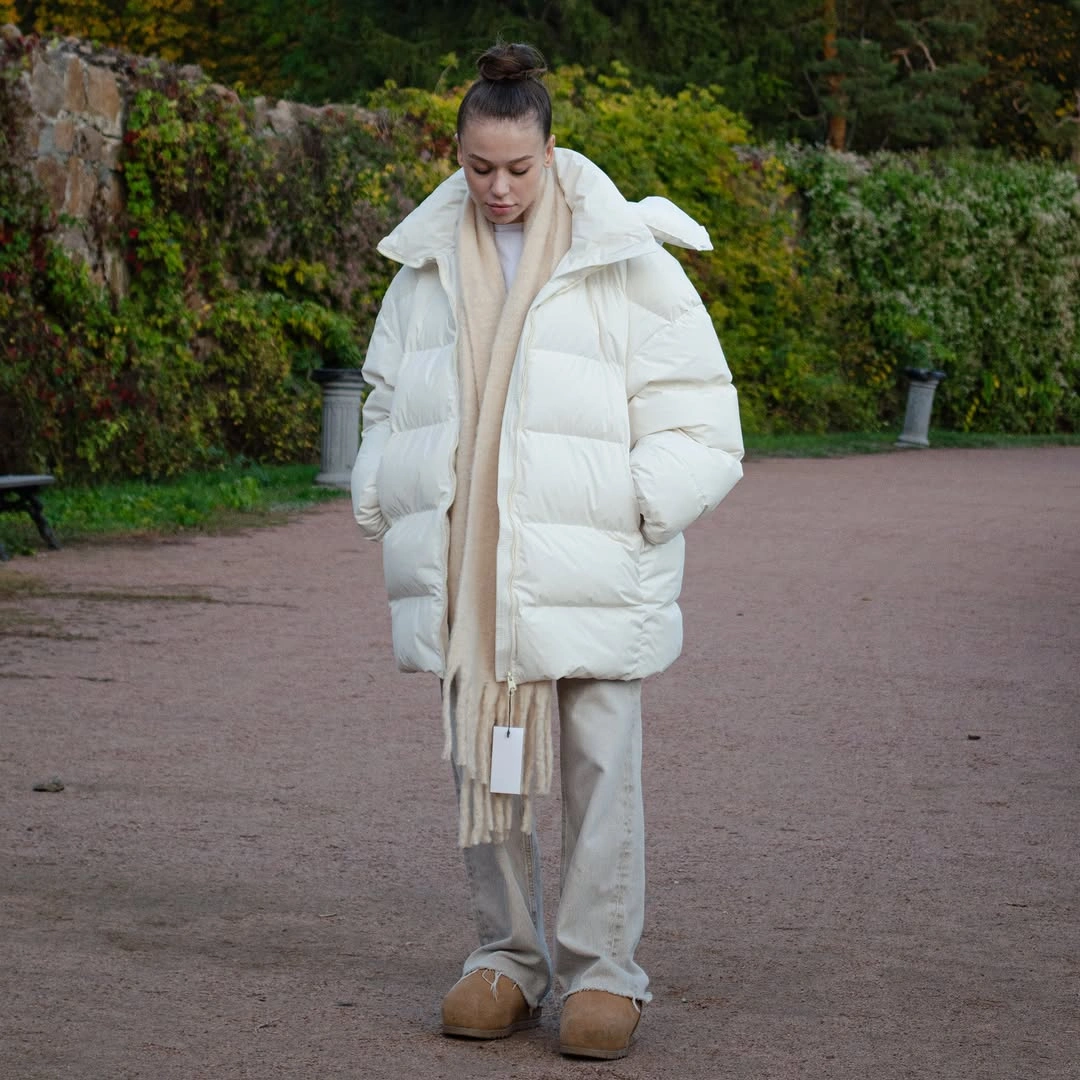 White oversized puffer with cream scarf, light pants and tan boots