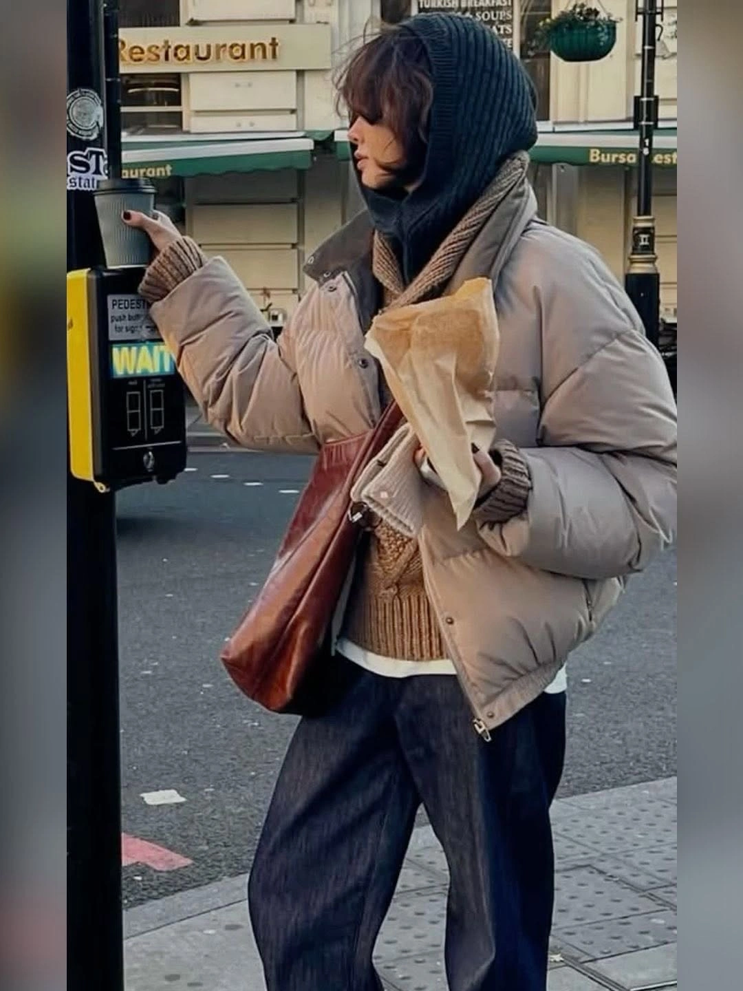 Beige cropped puffer with dark hooded layer and loose trousers
