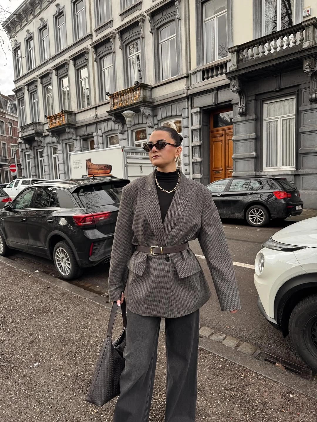 Gray belted blazer with black turtleneck and wide trousers