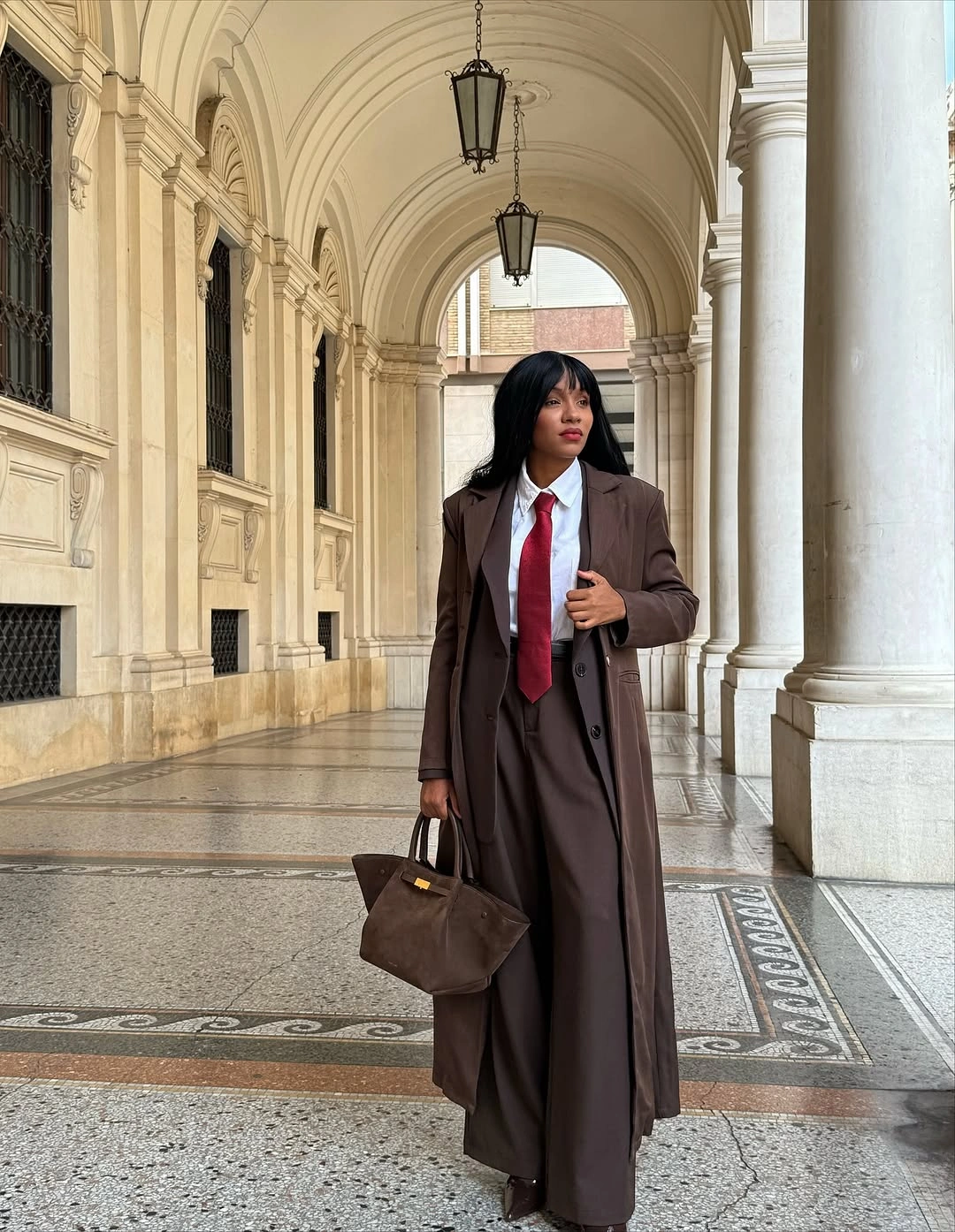 Brown long coat with white shirt red tie and trousers