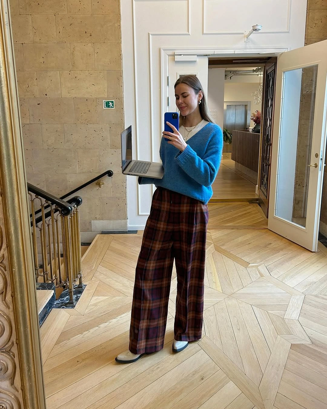 Blue V-neck sweater with brown plaid wide-leg trousers