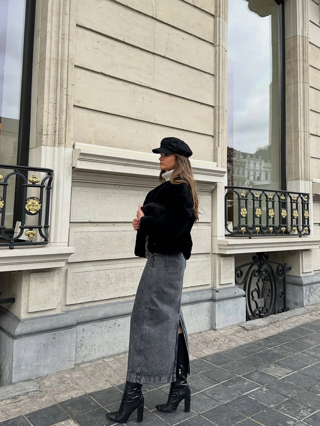 Black cropped jacket with long gray skirt and tall boots
