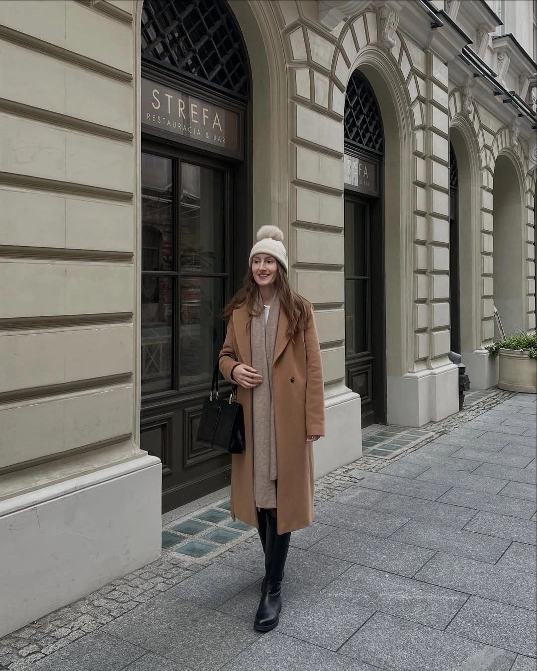 Long camel coat with pale scarf and black ankle boots