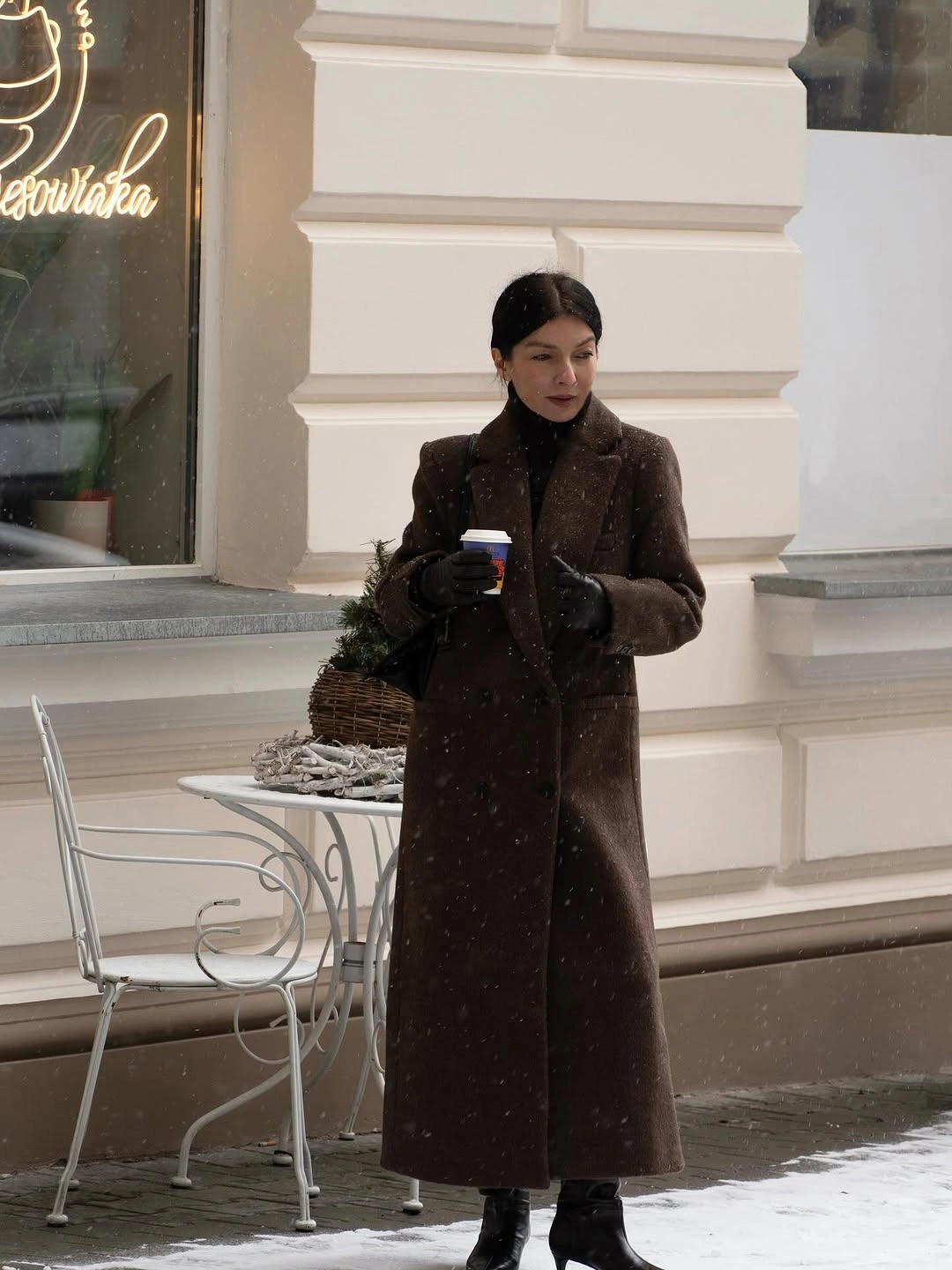 Long dark brown coat over black high neck layers and boots
