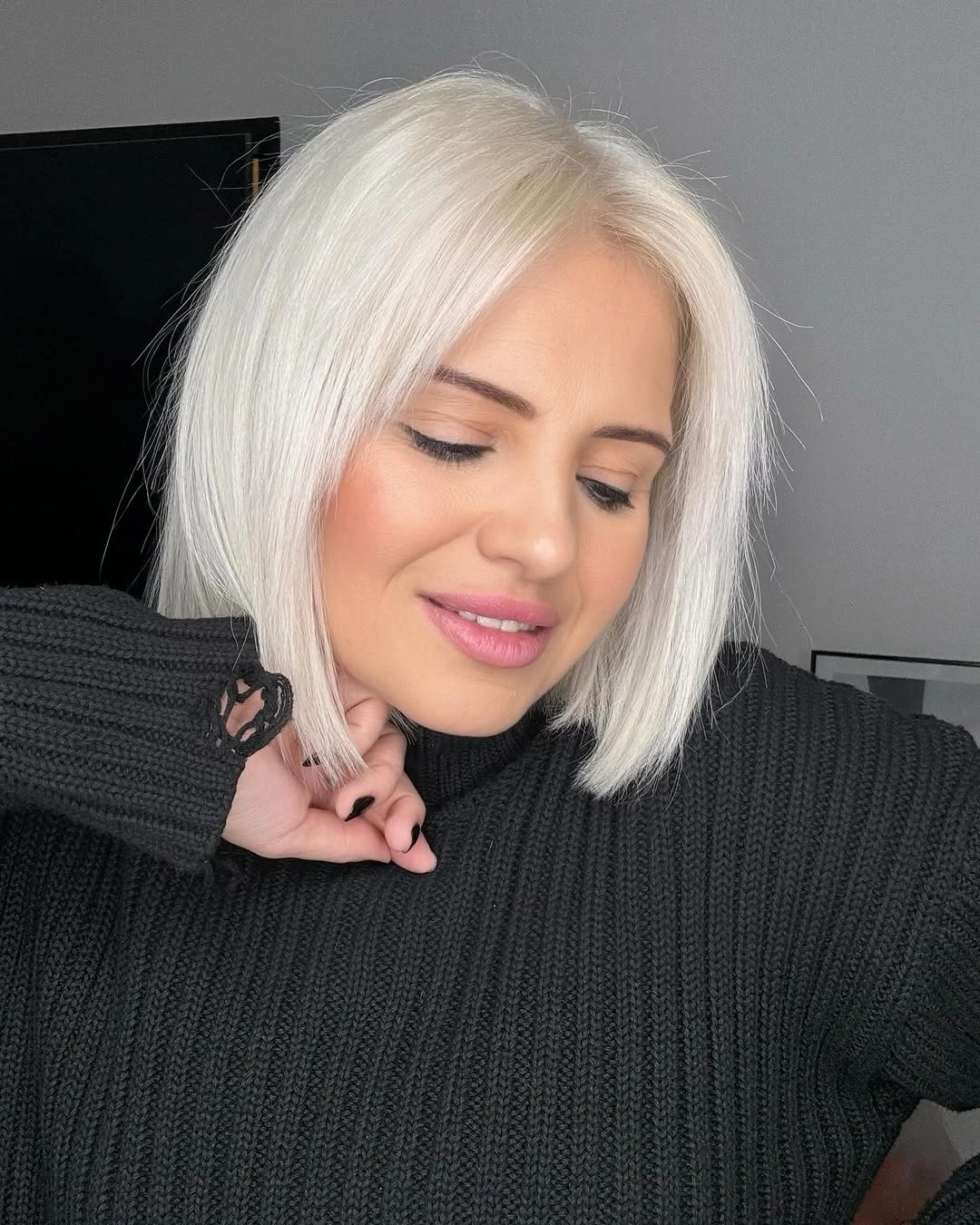 Short icy blonde bob with side part and rounded shape