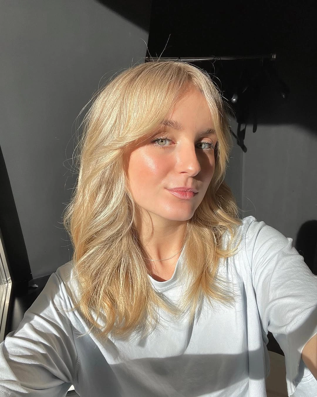 Medium warm blonde waves with side swept fringe