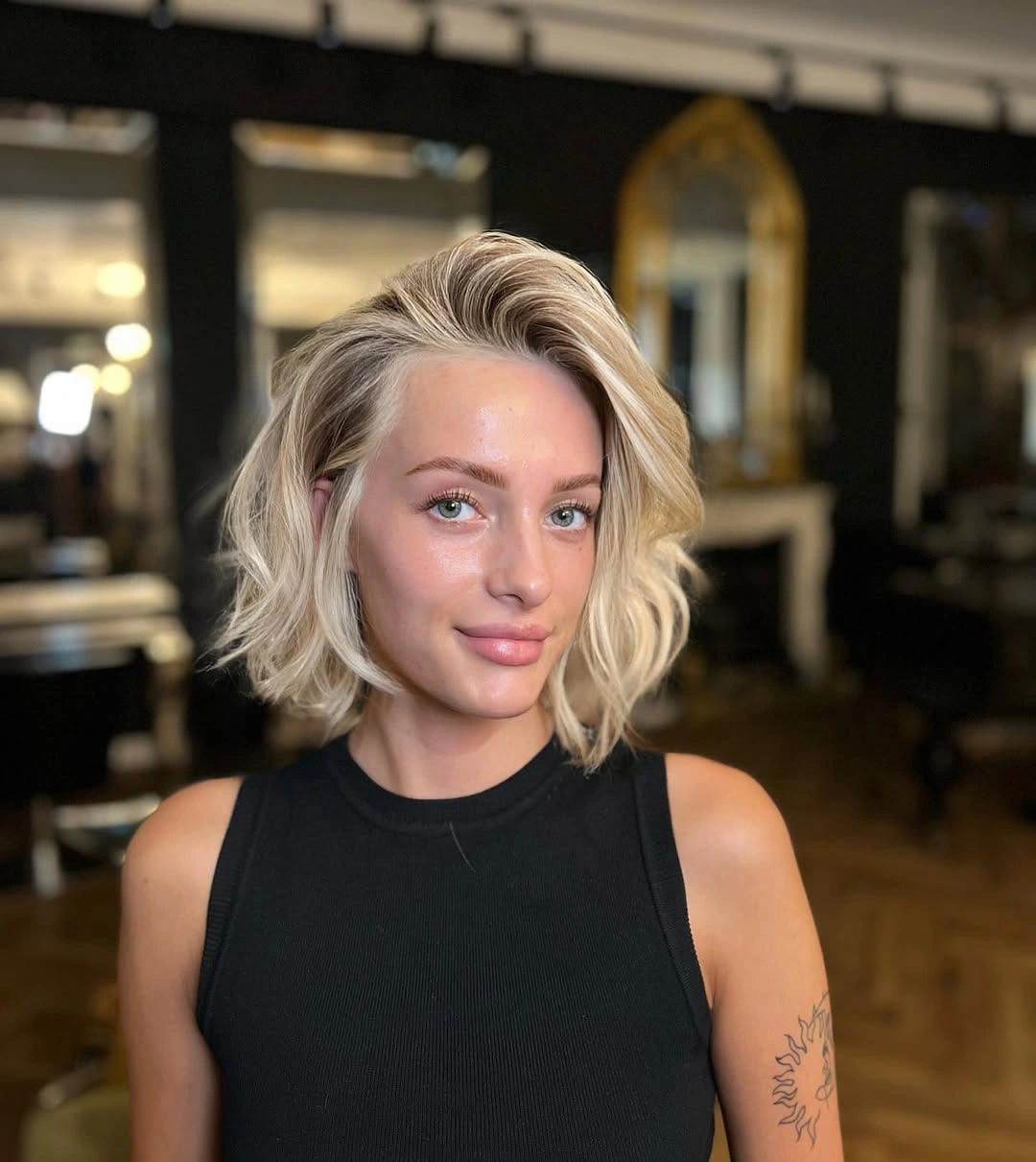 Short wavy beige blonde bob with side swept part