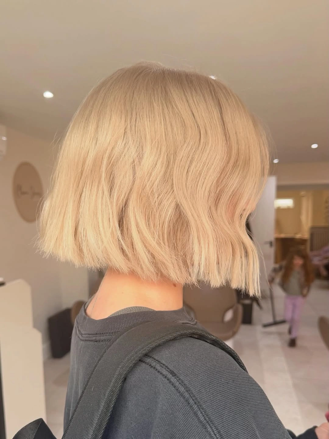Rear side view of peach beige blonde blunt bob