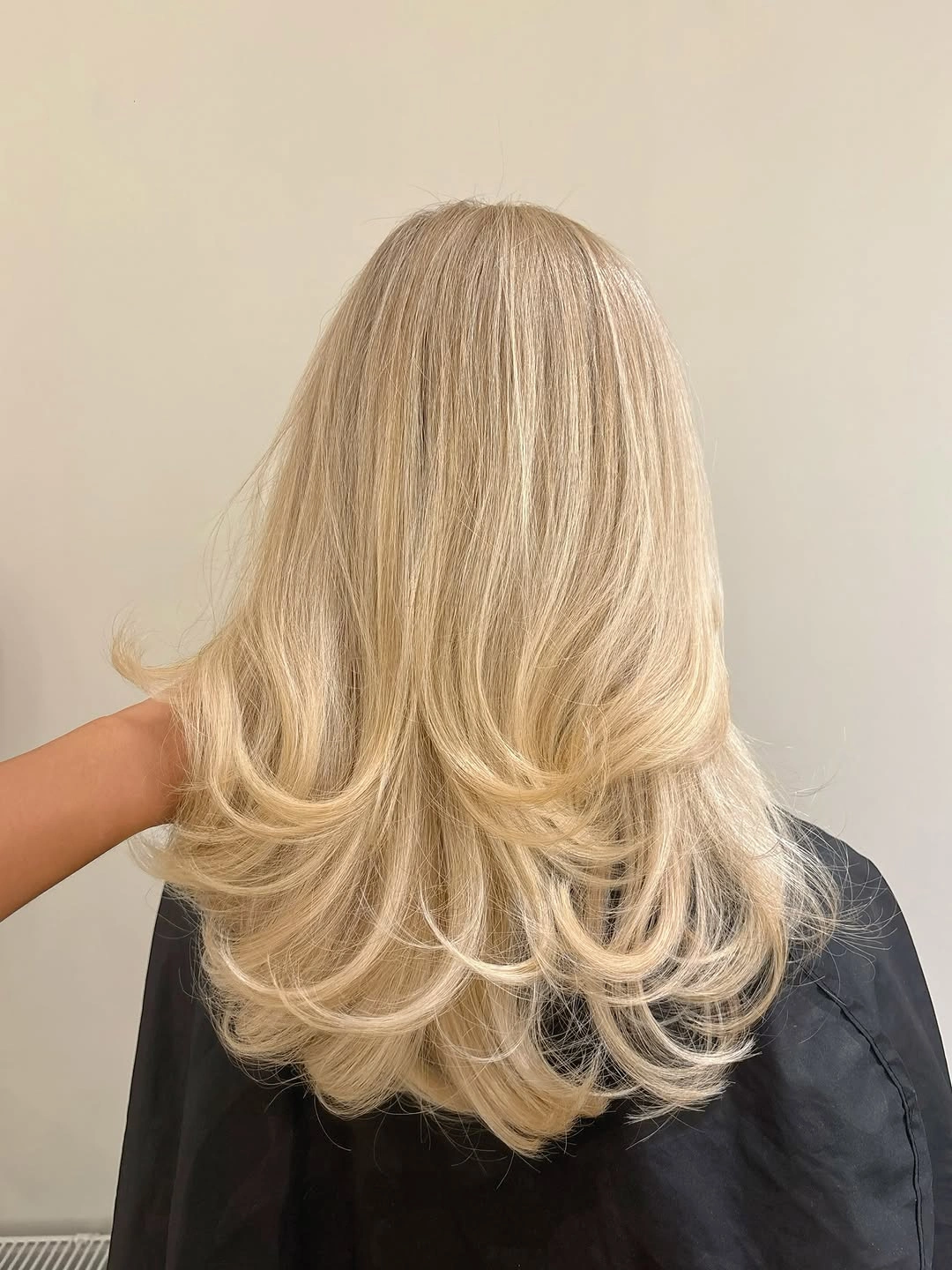 Back view of beige blonde hair with layered curled ends
