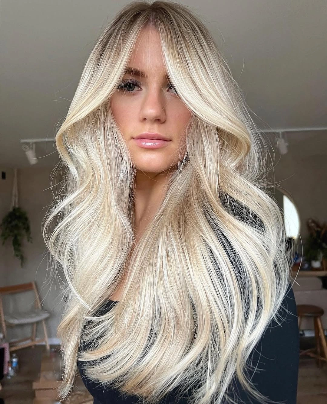 Long creamy blonde waves with center part and curtain fringe