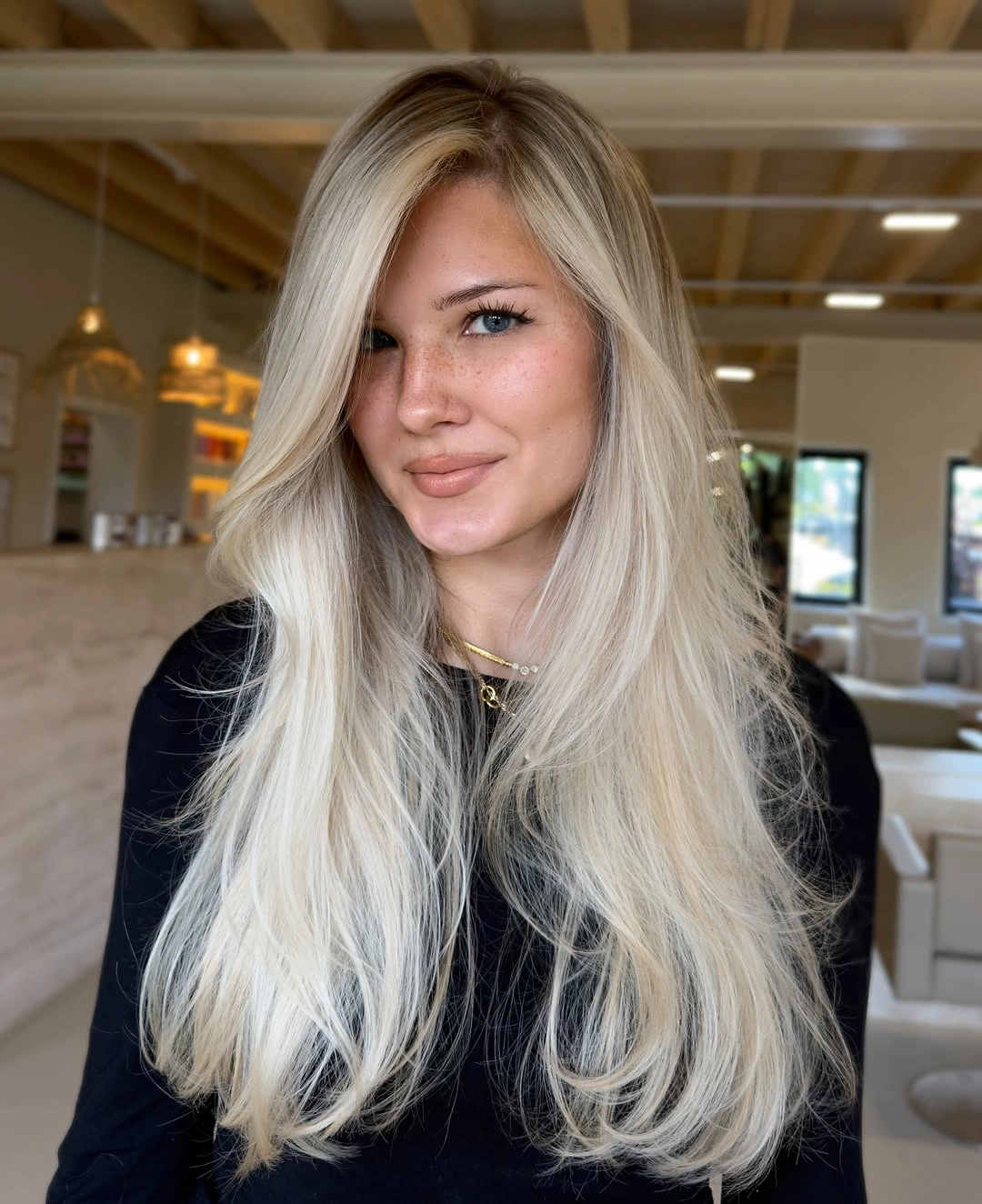 Long bright blonde layered hair with side-swept front volume