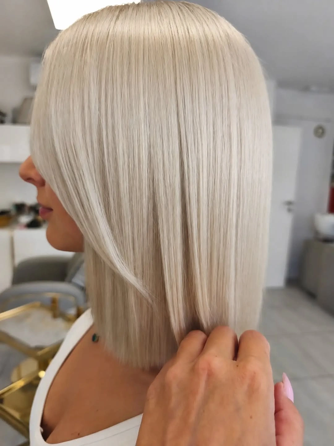 Side view of straight pale blonde bob with blunt edge