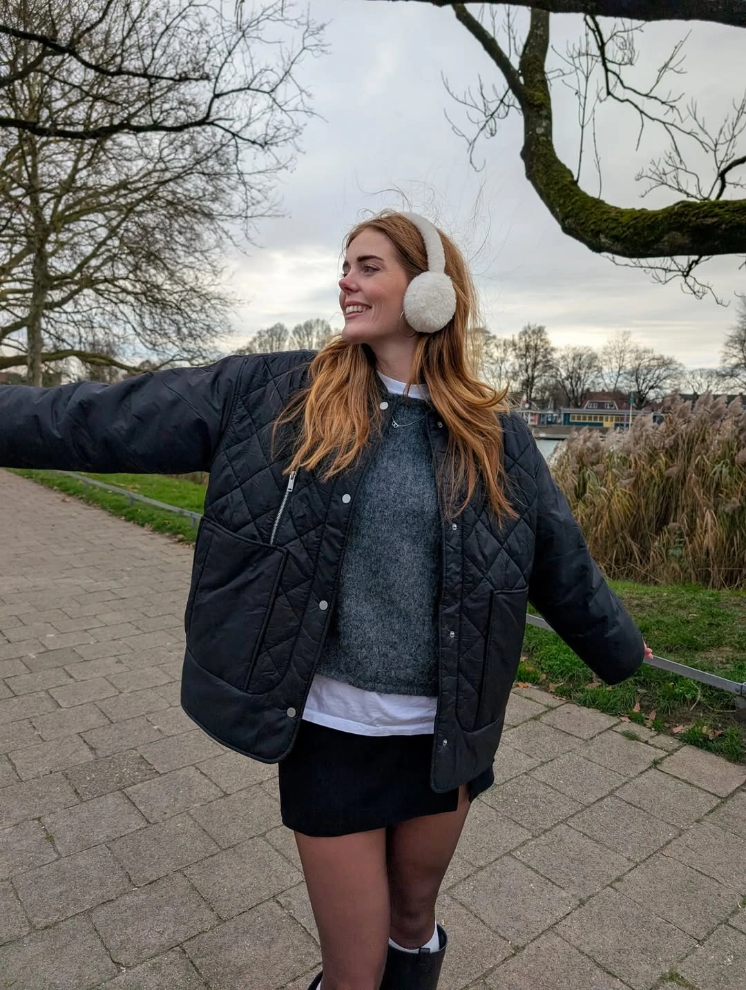 Black quilted jacket gray sweater skirt tights and earmuffs