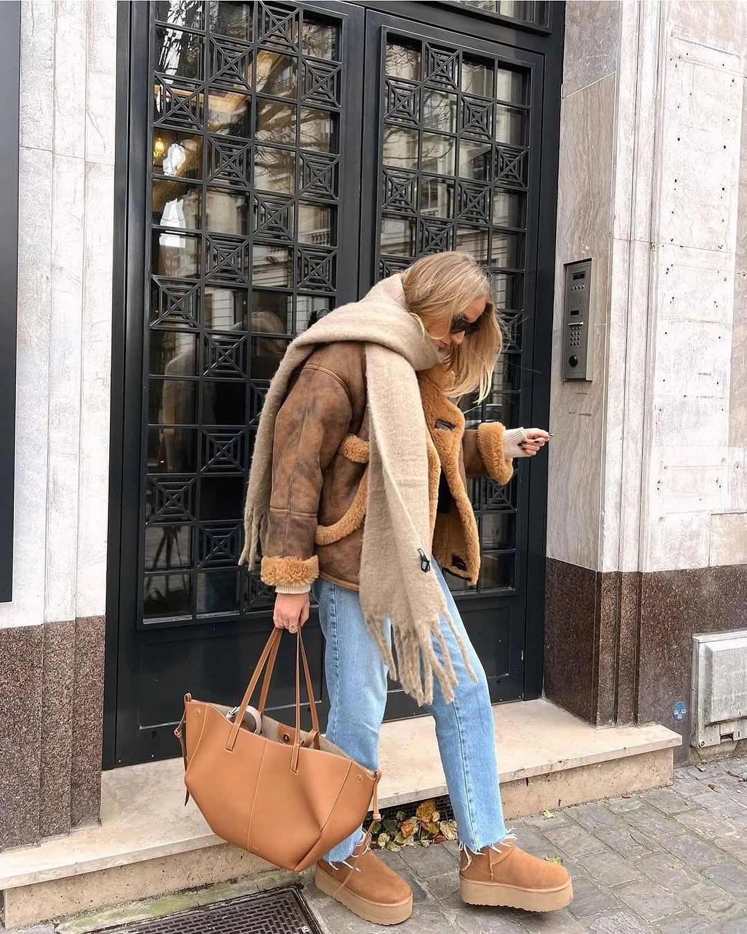 Brown trimmed jacket cream scarf pale jeans and platform boots