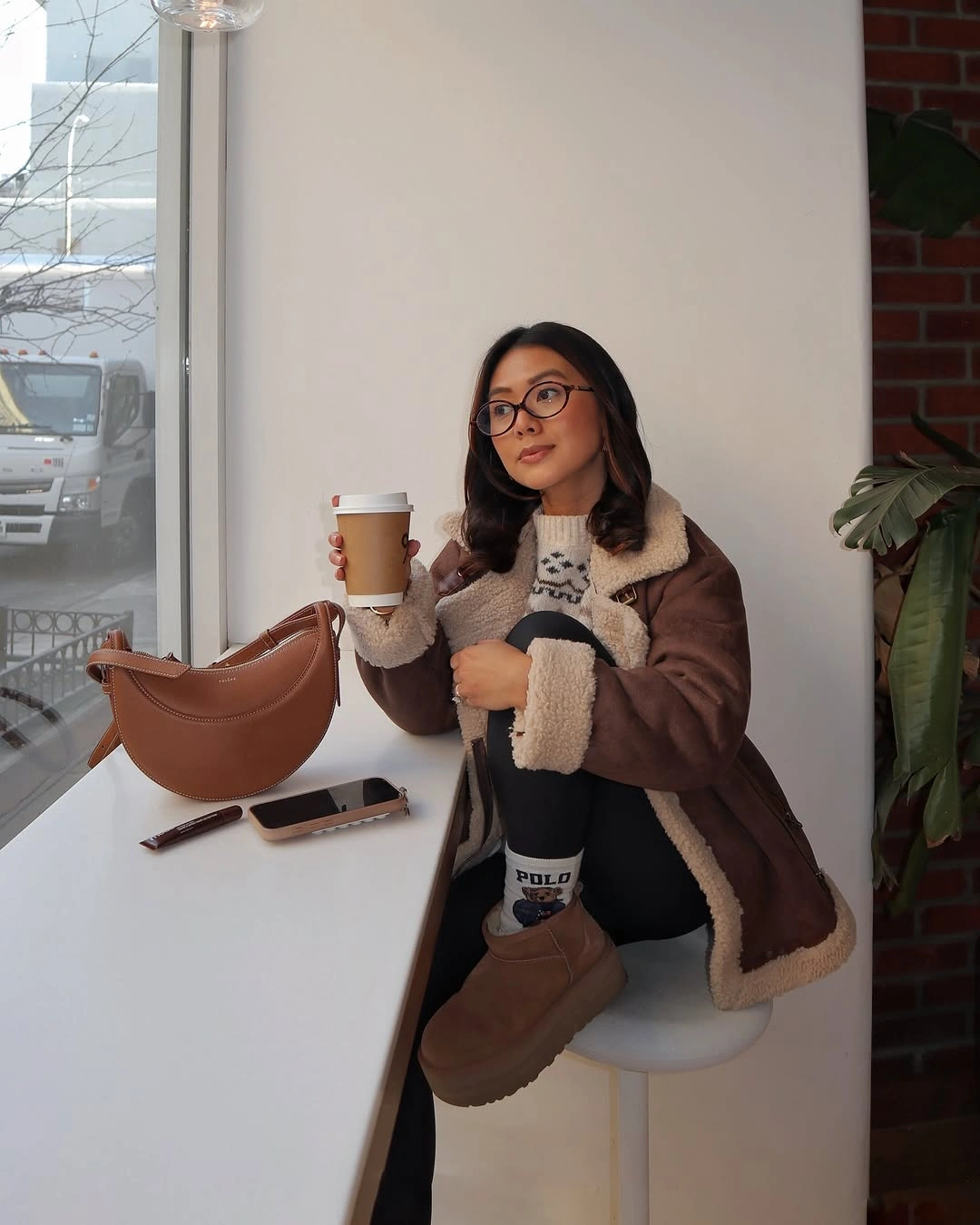 Brown cream-trim jacket black leggings and tan ankle boots