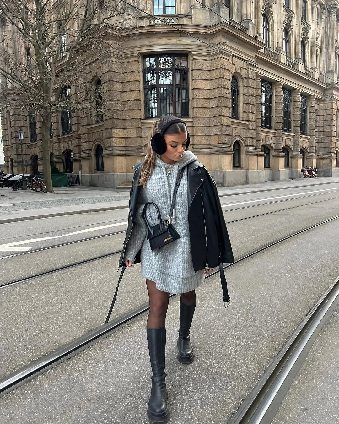 Plush taupe long coat with white wide trousers and black handbag