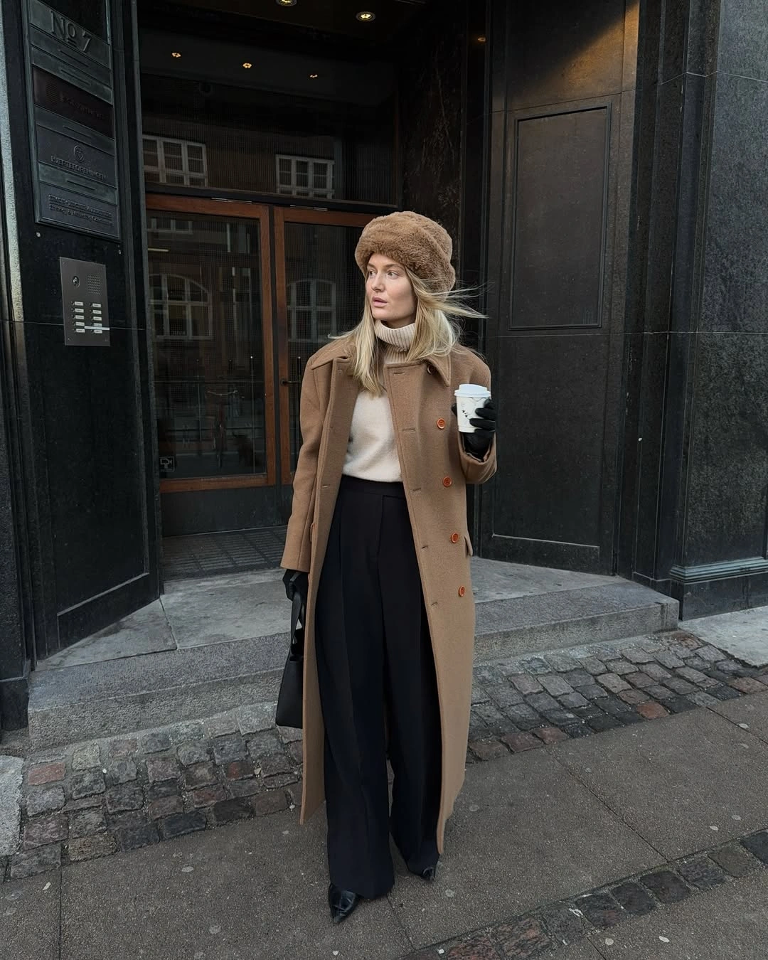 Long gray textured coat with cropped black pants and tan slip-ons