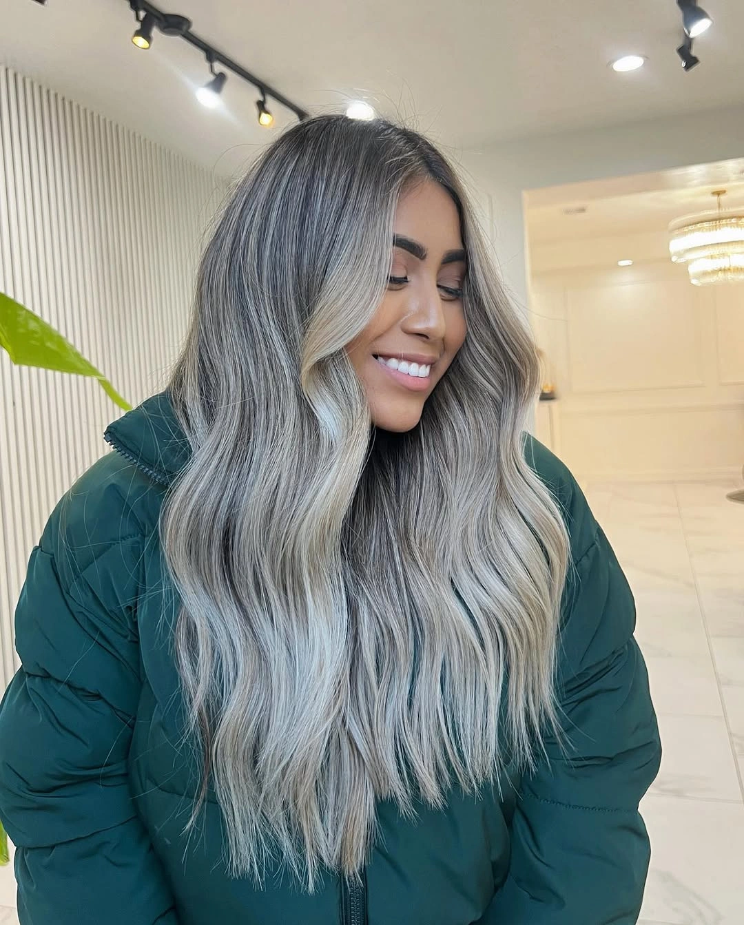 Long silver-blonde waves with darker root dimension