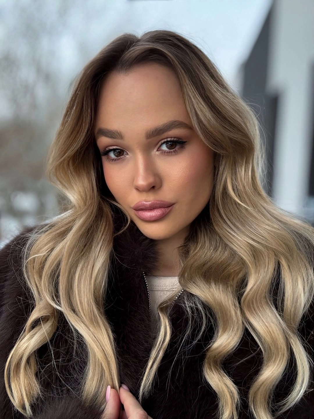 Long beige-blonde waves with darker root and pale front pieces