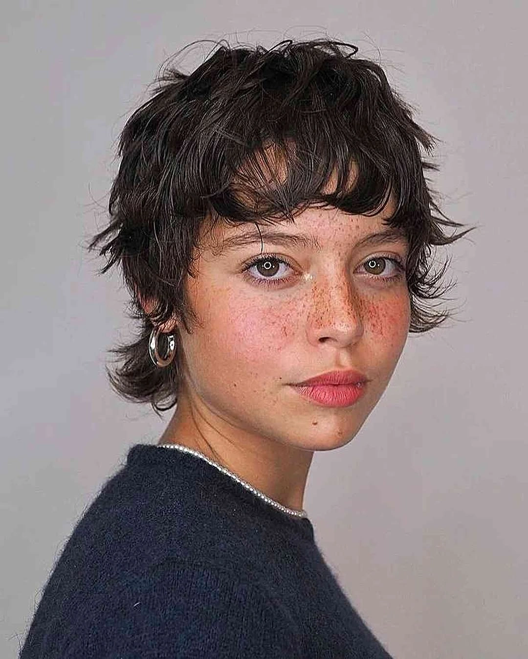 Short dark textured pixie-shag with irregular fringe and longer nape