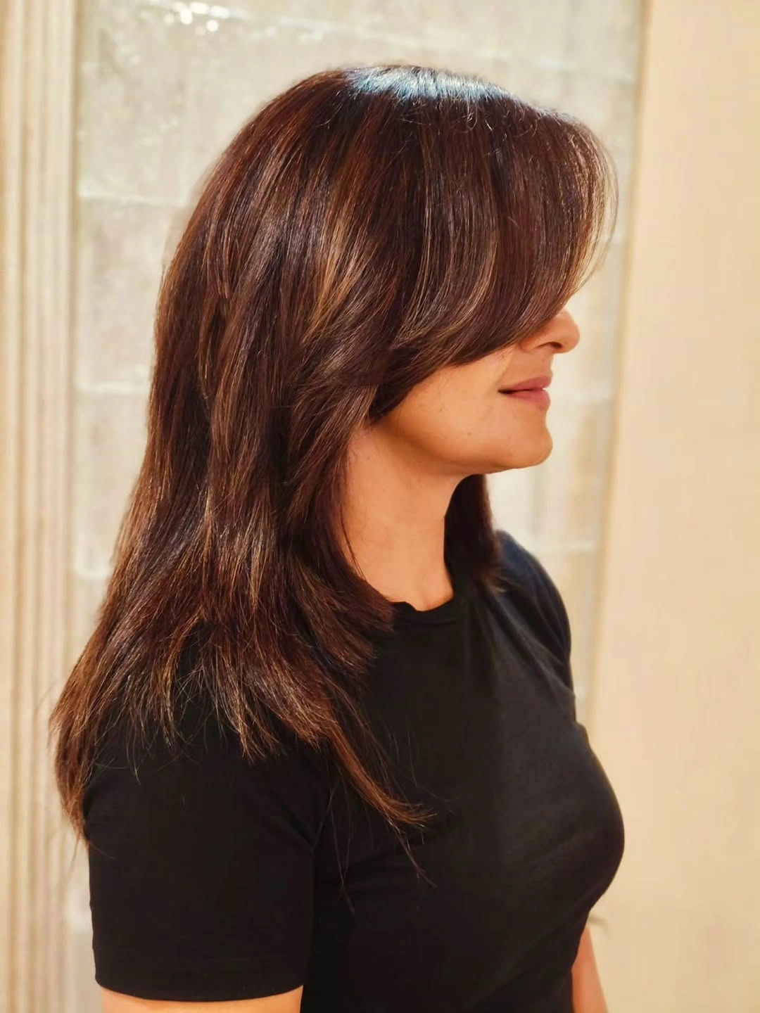 Medium-long brown haircut with side-swept layered front